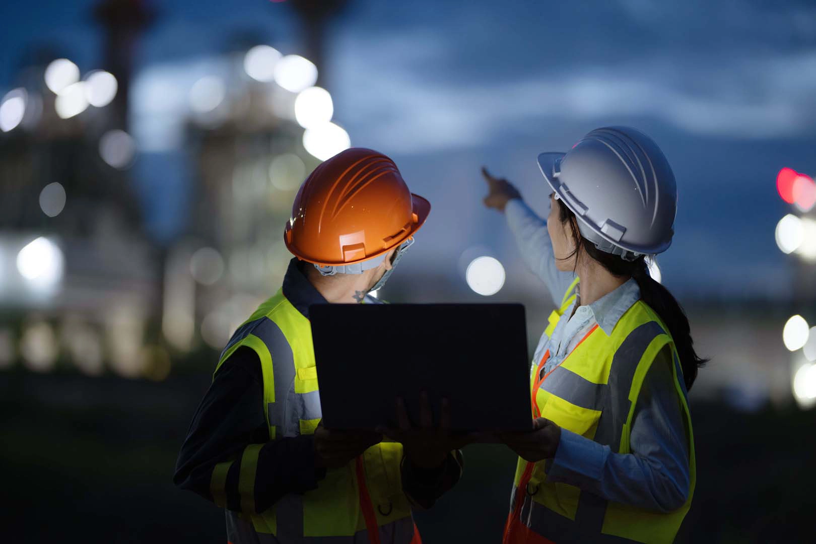 Workers in hard hats collaborate on site