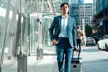 someone walking down the street with a suitcase