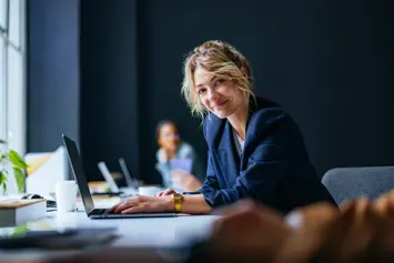 someone smiling while working on a laptop